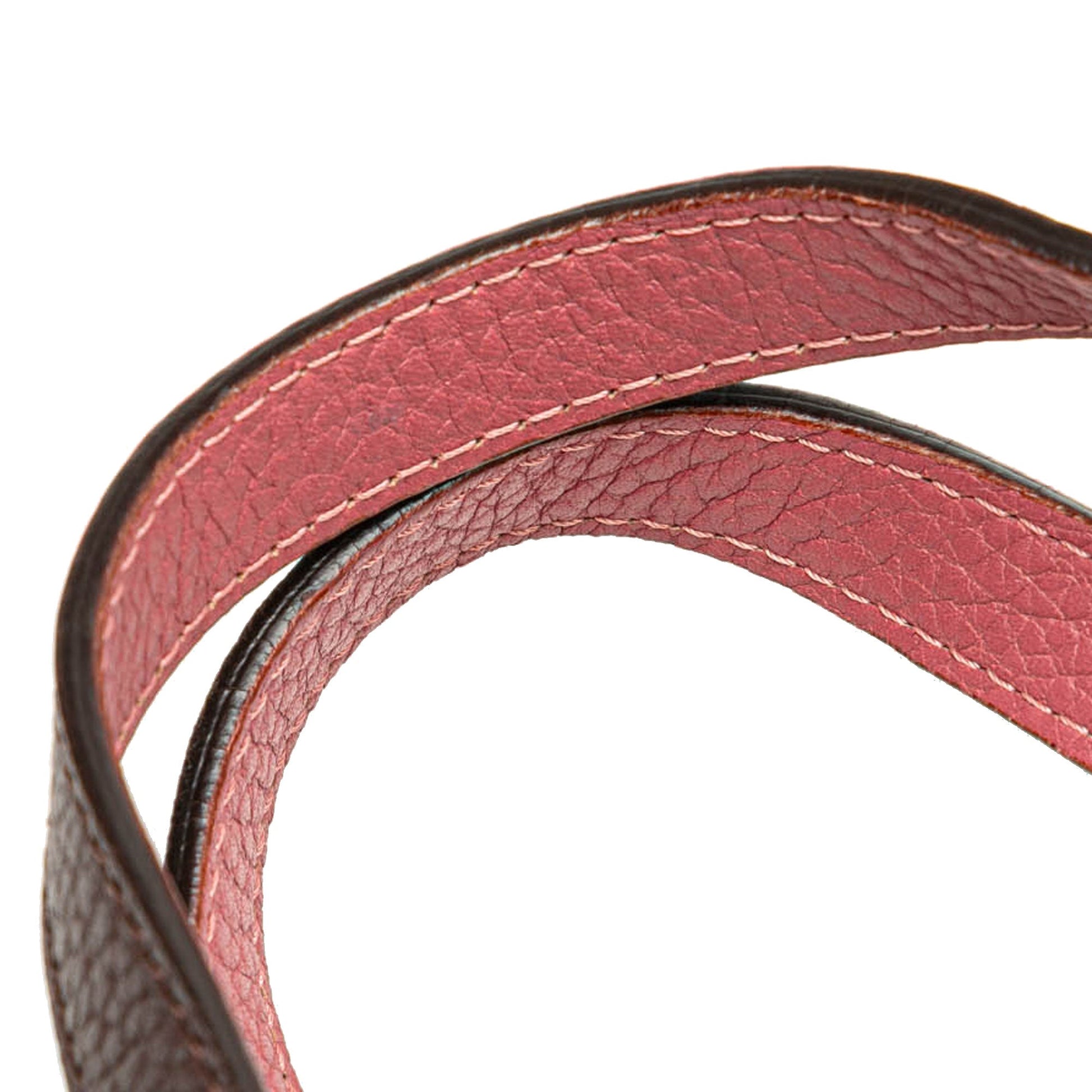 Detail of double leather shoulder straps with pink interior and brown exterior.