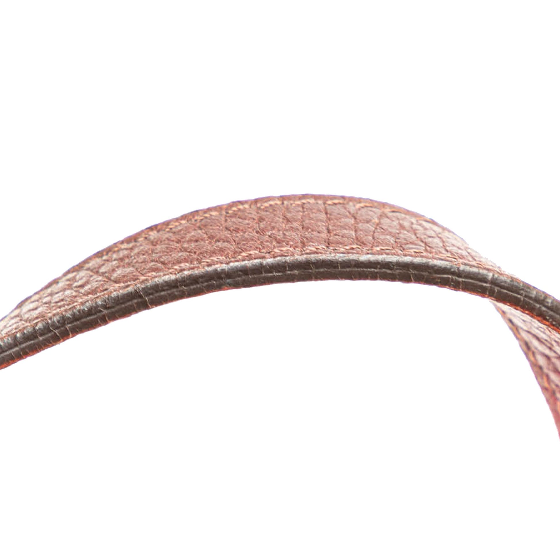 Zoomed-in view of a single leather handle showing stitching and contrasting pink lining.