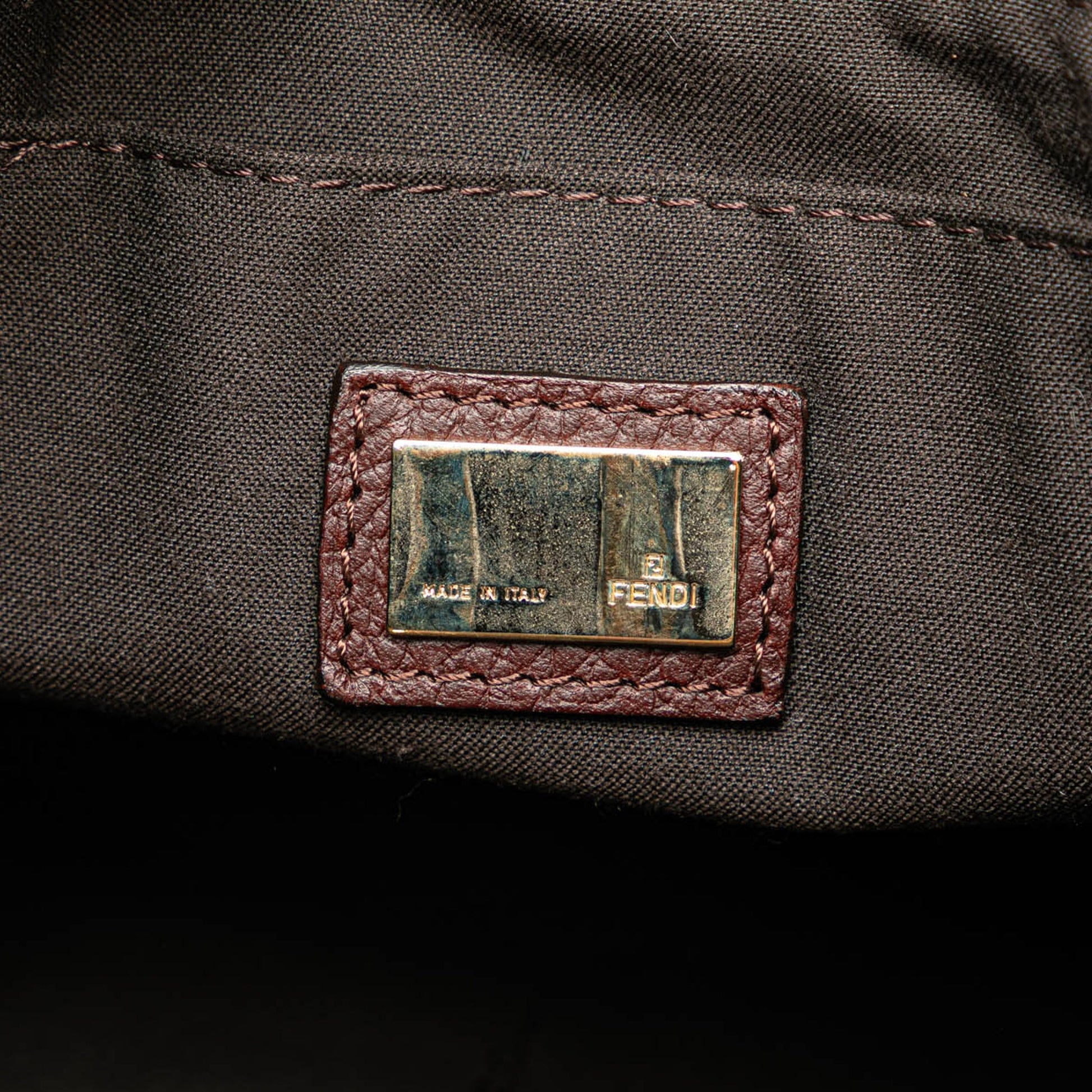 Interior pocket of the Fendi tote bag with brown leather trim on black fabric lining.